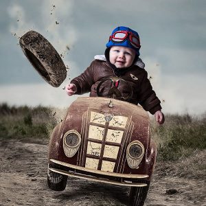 Family portrait - little boy in a dirty racing car