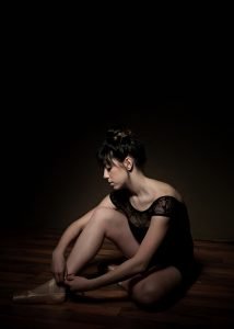 girl sat tying her ballet shoes