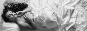 lady on a bed wrapped in a white sheet